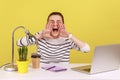 Nervous angry woman office worker in striped shirt loudly screaming holding hands near mouth. Royalty Free Stock Photo