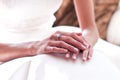Nervous hands of a woman on her wedding day, with her white dress ready