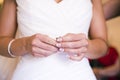 Nervous hands of a woman on her wedding day, with her white dress ready