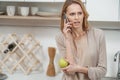 Nervous lady talking on phone in cook room