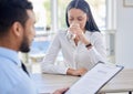 Nervous mixed race businesswoman drinking water in interview with hiring manager. CEO reading candidate resume looking Royalty Free Stock Photo