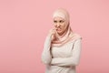 Nervous preoccupied young arabian muslim woman in hijab light clothes posing isolated on pink background. People