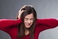 Nervous 30's brunette suffering from migraine, covering her ears with her hands Royalty Free Stock Photo