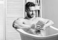 Nervous system benefit bathing. Relax concept. Man muscular torso relax bathtub and read book. Relaxed guy reading book Royalty Free Stock Photo