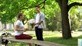 Nervous teenager presenting flowers to pretty girl in park, pick up master