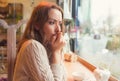 Nervous woman biting nails and looking away sitting alone in a coffee shop Royalty Free Stock Photo