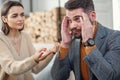 Nervous young man trying to doesn`t listen to his girlfriend in the bedroom. Royalty Free Stock Photo