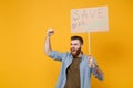 Nervous young protesting man hold protest sign broadsheet placard on stick clenching fist scream isolated on yellow