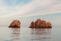 Nes Portes Rocks with a cross on top, north of Paros Island sticking out from perfectly flat Mediterranean Sea, Greece