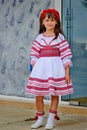 Nesebr, Bulgaria - 13 June, 2013: small dark-haired girl with flowers on her head is standing in a national dance costume