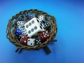 Nest with colored dice inside , on blue background