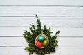 Nest colored eggs wreath on white wooden planks background