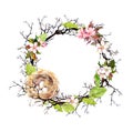 Nest with eggs, spring blossom flowers, branches and green leaves. Floral wreath for Easter. Watercolor circle border