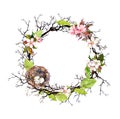 Nest with eggs, spring blossom flowers, branches and green leaves. Floral wreath for Easter. Watercolor circle border