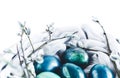 Nest of fabric with Easter eggs in turquoise and gold decorated with pussy willow on white. Place for text. Royalty Free Stock Photo