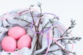 Nest of fabric with pink Easter eggs decorated with silk ribbons and pussy willow on white. Royalty Free Stock Photo