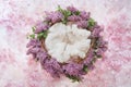 Nest of grapevine and lilac flowers for photographing newborns on a pink floral background