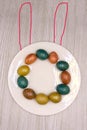 A nest with three colored Easter eggs and bunny ears at home on Easter day. Celebrating Easter at spring. Painting eggs. Royalty Free Stock Photo