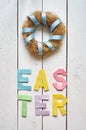 Nest wreath, easter folded paper origami colorful lettering on white wooden planks rustic background