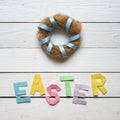 Nest wreath, easter folded paper origami colorful lettering on white wooden planks rustic background