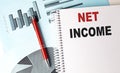 NET INCOME text on notebook on chart background Royalty Free Stock Photo