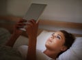 On the net at night. an attractive young woman using her tablet in bed. Royalty Free Stock Photo