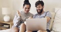 Net shows and chill. a happy young couple using a laptop and eating popcorn while relaxing on the bed at home. Royalty Free Stock Photo