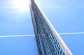 Net of tennis court with white border line on blue floor