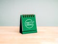 2050 NET ZERO goal plan concept. Net Zero logo icon graphics on green small desk calendar cover standing on wooden table and grey
