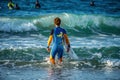 12/18/2018 Netanya, Israel, a surfer with a board goes swimming in the ocean at the dawn of the day