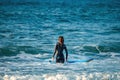 12/18/2018 Netanya, Israel, a surfer with a board goes swimming in the ocean at the dawn