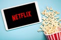 Netflix logo on the screen of a white digital tablet with popcorn Royalty Free Stock Photo