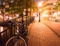 NETHERLANDS, AMSTERDAM - 23 AUG 2018: Night city view of Amsterdam. Bicycles on a Channel bridge and typical dutch