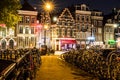 NETHERLANDS, AMSTERDAM - 23 AUG 2018: Night city view of Amsterdam Bridge over the channel with parked bicycles and Royalty Free Stock Photo