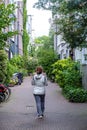 Netherlands, Leiden town. Lady walks between traditional red brickwall buildings. Vertical