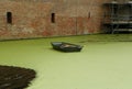 Netherlands, Muiden Castle, abandoned boat in a ditch with water near the fortress