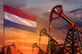 Netherlands oil industry concept. Industrial illustration - Netherlands flag and oil wells with the red and blue sunset or sunrise