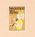 A stamp printed in the Netherlands shows a child playing the flute, circa 1960