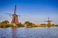 Netherlands Traveling. Traditional Dutch Windmill and House in Kinderdijk Village in the Netherlands At Daytime Royalty Free Stock Photo