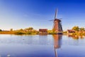 Netherlands Traveling. Traditional Dutch Windmill and Dutch Houses in Kinderdijk Village in the Netherlands At Daytime Royalty Free Stock Photo