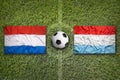 Netherlands vs. Luxembourg flags on soccer field Royalty Free Stock Photo
