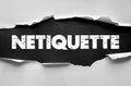 Netiquette text torn paper concept representing online manners, digital communication behavior, respectful interaction, and Royalty Free Stock Photo