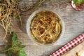 Nettle root tincture in a glass jar on a table