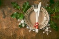 Netural, scandinavian style christmas dinner table setting: simple wooden table with silverware