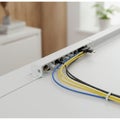 A network cable organizer attached to a sleek, white desk. Several Ethernet cablesâ Royalty Free Stock Photo