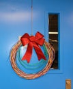 Network Cabling Christmas wreath with glittery bow hung on blue door Royalty Free Stock Photo