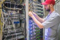 Network engineer switches power cables in the server room rack. The system administrator works in the data center. Portrait of a Royalty Free Stock Photo