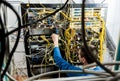 Network engineer working in server room. Connecting network cables to switches Royalty Free Stock Photo