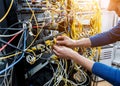 Network engineer working in server room. Connecting network cables to switches Royalty Free Stock Photo