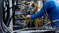 Network engineer working in server room. Connecting network cables to switches Royalty Free Stock Photo